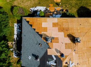 Home with roof replacing new shingles, felt paper, and tools a worker replaces shingles